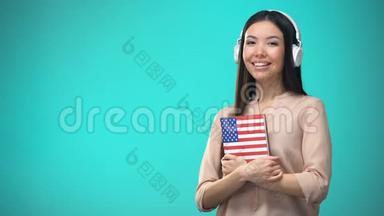 女学生听美国英语录音耳机，手拿书